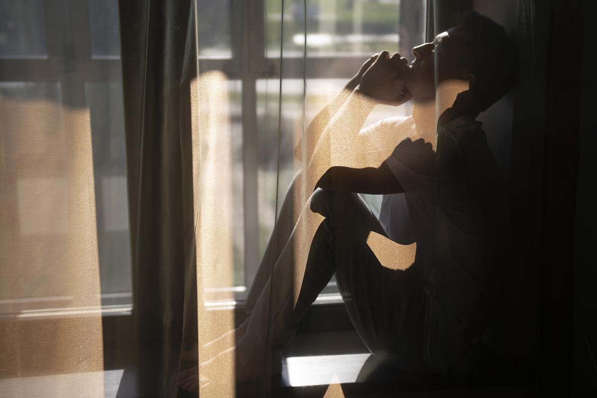 creative portrait man with curtains shadows from window